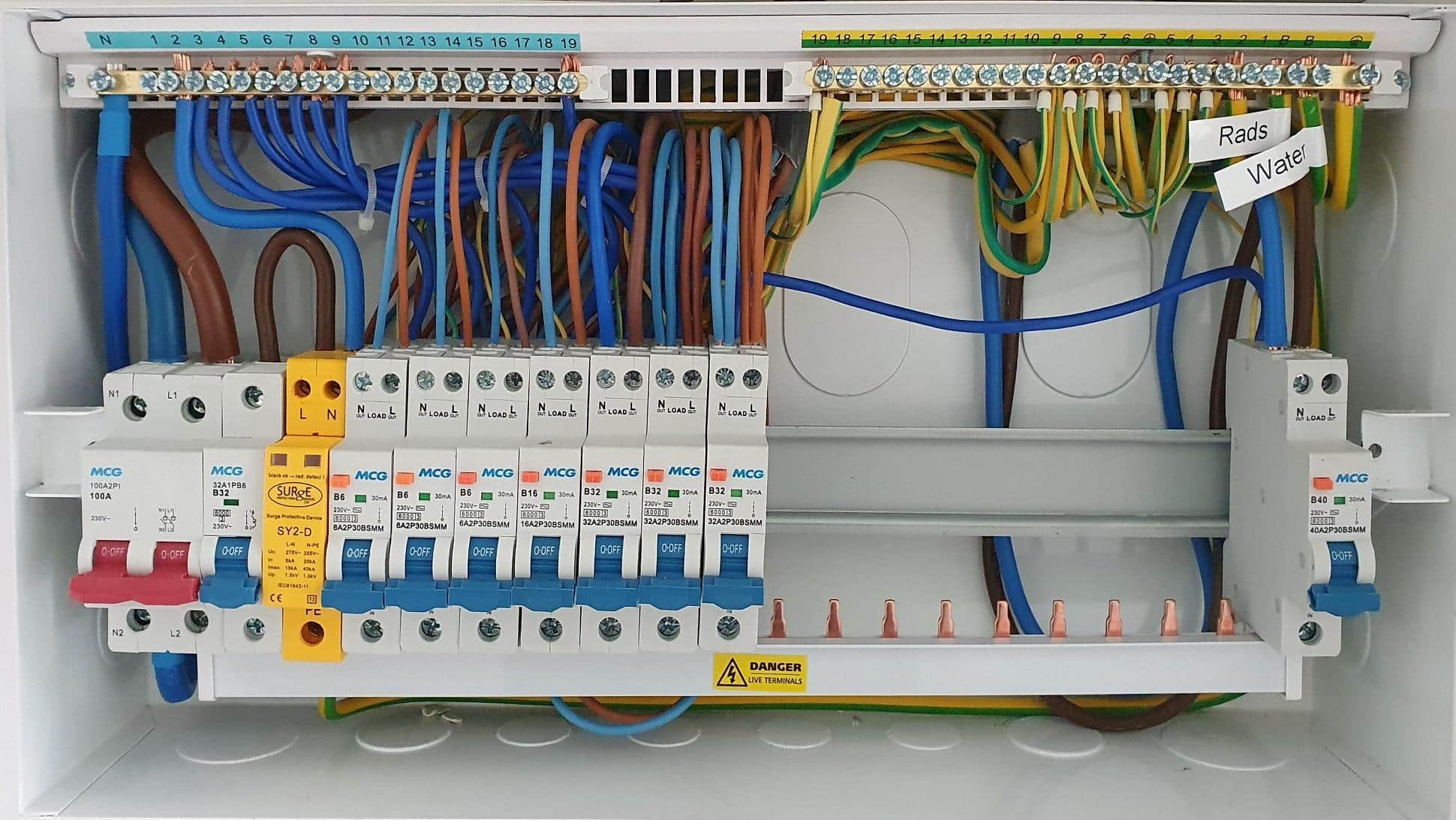 A close-up of a modern consumer unit installation with neatly labelled circuits and tidy cabling.
